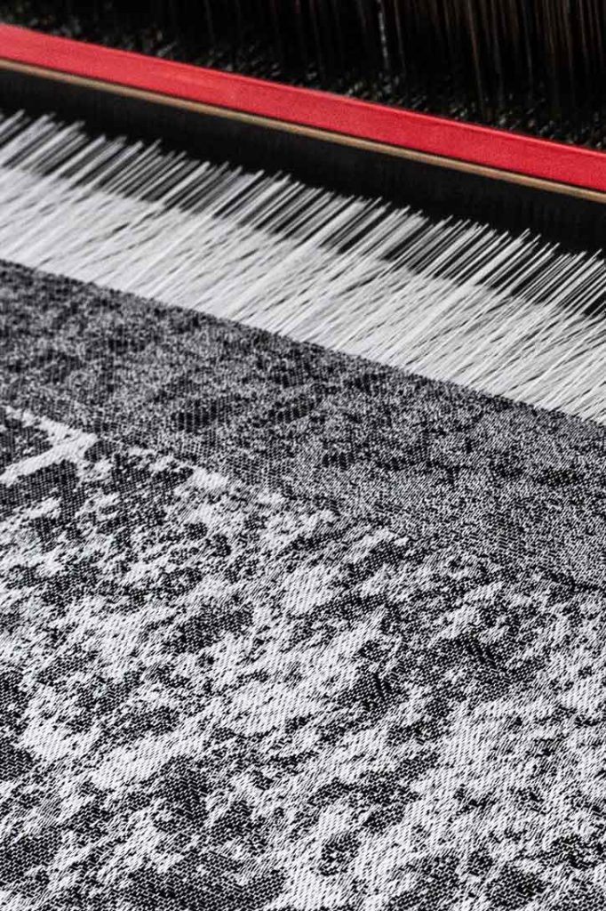     Tessuto jacquard LICHENI® bianco e nero in lavorazione sul telaio